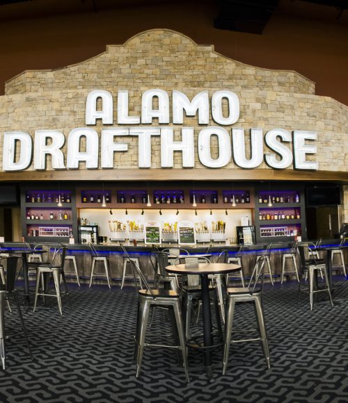 interior of the main lobby of the alamo drafthouse showing the bar and seating.